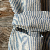 Gaiši zilas/dabīgi pelēkas svītriņas (~2.5mm), viegli mīkstināta lina auduma priekšauts ar kabatiņu un regulējamām lencēm