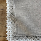 Nekrāsota, dabīgi pelēka toņa mīkstināta lina galda salvete ar divkrāsainu greznu lina mežģīni