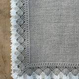 Nekrāsota, dabīgi pelēka toņa mīkstināta lina galda salvete ar divkrāsainu greznu lina mežģīni