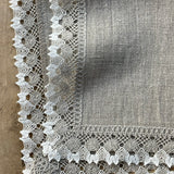 Nekrāsota, dabīgi pelēka toņa mīkstināta lina galda salvete ar divkrāsainu greznu lina mežģīni