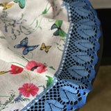 Magones, vanagzirņi, kosmejas un tauriņi- lina galdauts ar 12cm platu divkrāsaini zilu lina mežģīni