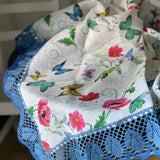 Magones, vanagzirņi, kosmejas un tauriņi- lina galdauts ar 12cm platu divkrāsaini zilu lina mežģīni