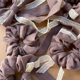 Lina auduma matu gumija - scrunchie - ar dekoratīvu banti Šokolādes lavandas tonis, ar mežģīni