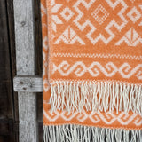 Koši oranžs aitas vilnas pleds ar baltām bārkstīm un etnogrāfiska stila ornamentiem