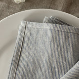 Mīkstināta vidēji plāna lina galda salvetes ar gaiši zilām/dabīgi pelēkām sīkām svītriņām un šaurām maliņām