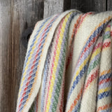 Krāsainas svītriņas uz piena balta fona aitas vilnas pleds ar bārkstīm