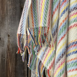 Krāsainas svītriņas uz piena balta fona aitas vilnas pleds ar bārkstīm