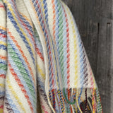 Krāsainas svītriņas uz piena balta fona aitas vilnas pleds ar bārkstīm