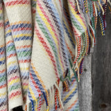 Krāsainas svītriņas uz piena balta fona aitas vilnas pleds ar bārkstīm