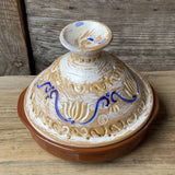 Tadžina 22 cm dia ar baltu vāku, reljefu marokāņu stila ornamentu dzeltenos un zilos toņos un brūnu šķīvi