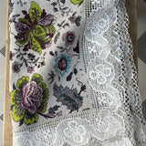 Krāsains lina galdauts ar ziediem ar ~6cm platu balti-pelēku lina mežģīni ar ziedu rakstu