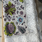 Krāsains lina galdauts ar ziediem ar ~6cm platu balti-pelēku lina mežģīni ar ziedu rakstu