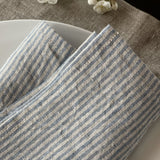 Mīkstināta vidēji plāna lina galda salvetes ar gaiši zilām/dabīgi pelēkām vidēji platām svītriņām un šaurām maliņām