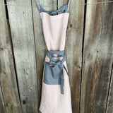 Maigi rozā toņa lina auduma priekšauts ar tumši pelēkām lencēm un kabatiņu