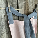 Maigi rozā toņa lina auduma priekšauts ar tumši pelēkām lencēm un kabatiņu