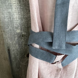 Maigi rozā toņa lina auduma priekšauts ar tumši pelēkām lencēm un kabatiņu