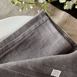 Mīkstināta vidēji plāna lina tumši pelēkas galda salvetes ar šaurām maliņām